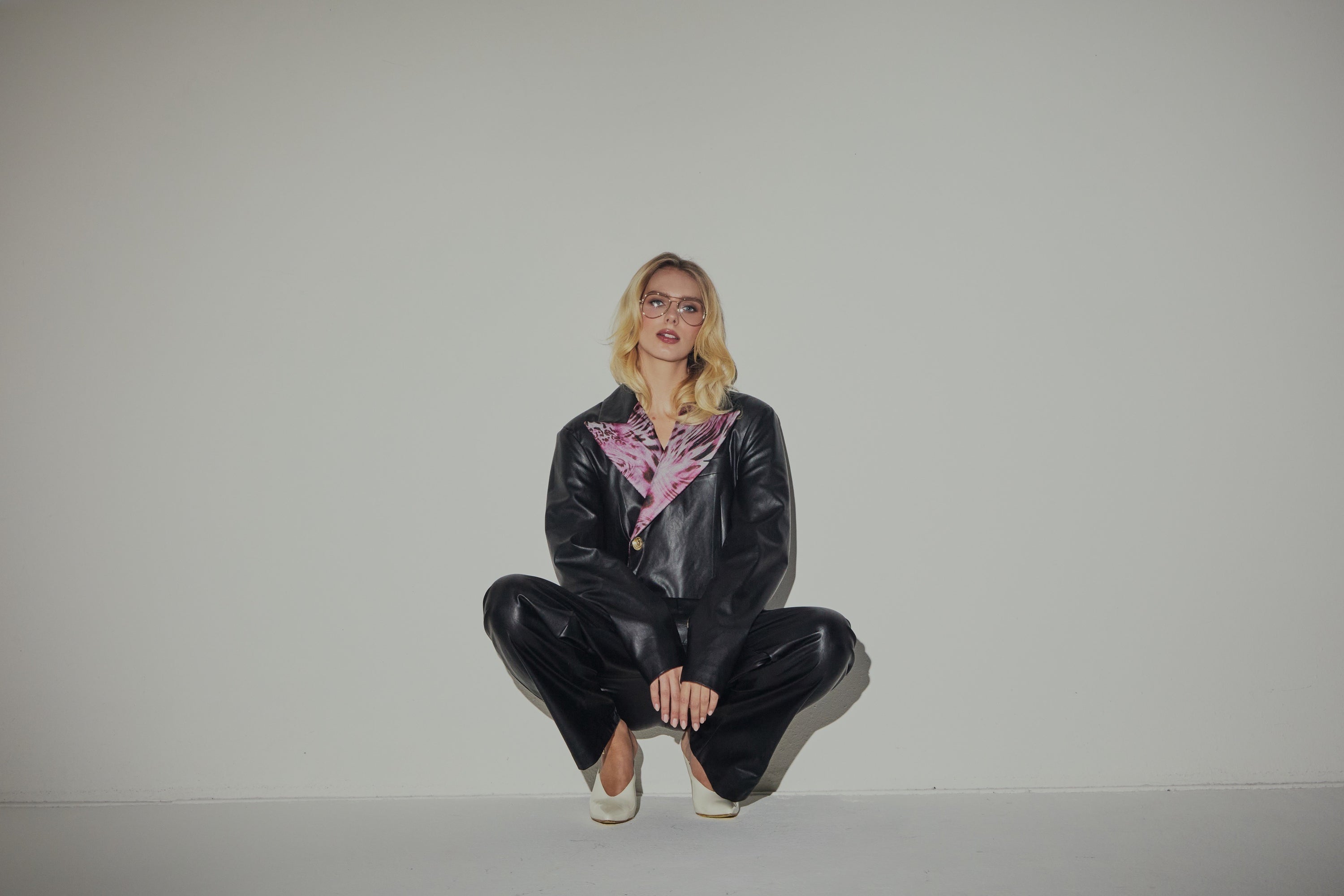 Schwarzer Blazer-Overall aus Kunstleder und rosa Animalier